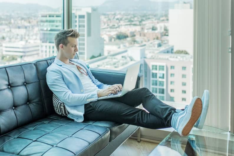 Image 4 man sitting out couch with laptop
